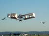 Rplica do 14 bis, fabricada e pilotada por Alan Calassa, voando entre duas rplicas do Demoiselle.